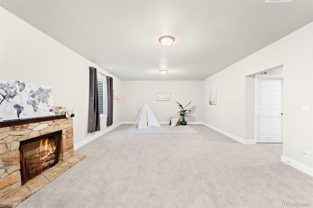 interior space featuring light colored carpet and a fireplace