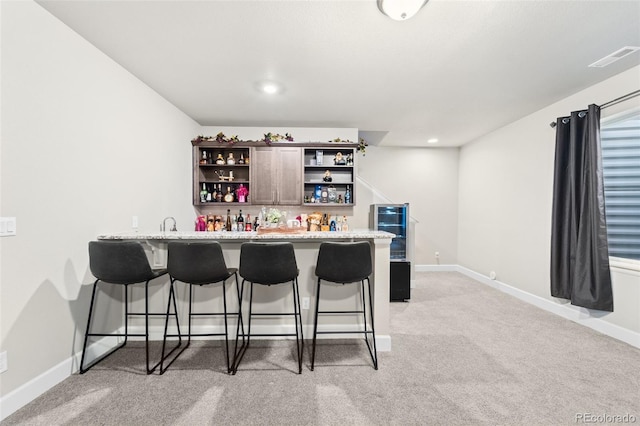 bar featuring light stone counters and light carpet