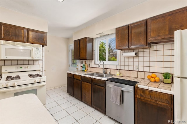 430 S Potomac Cir, Aurora, CO 80012 - kitchen featuring white appliances, a sink, tile counters, tasteful backsplash, and dark brown cabinets