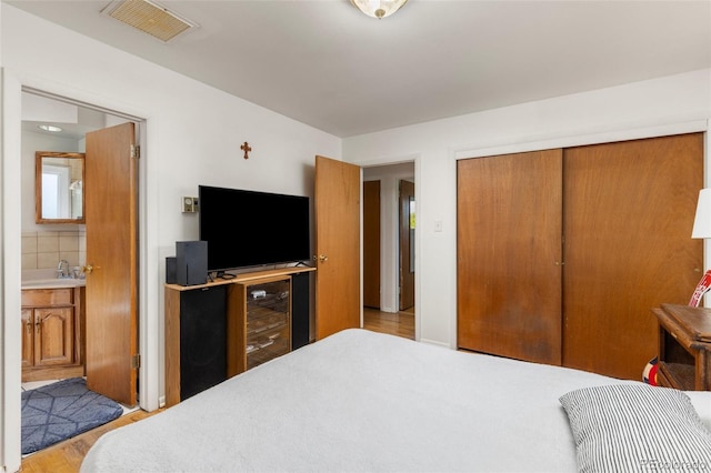 430 S Potomac Cir, Aurora, CO 80012 - bedroom with a closet, ensuite bath, a sink, and wood finished floors