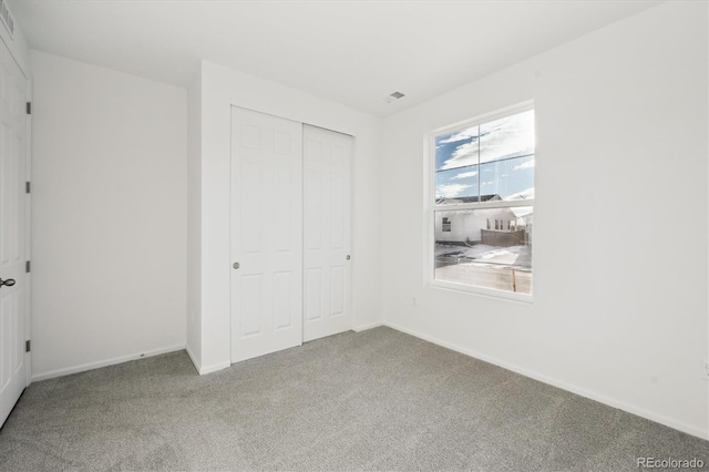 unfurnished bedroom with carpet and a closet