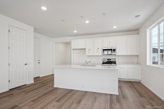 kitchen featuring appliances with stainless steel finishes, sink, white cabinetry, and an island with sink