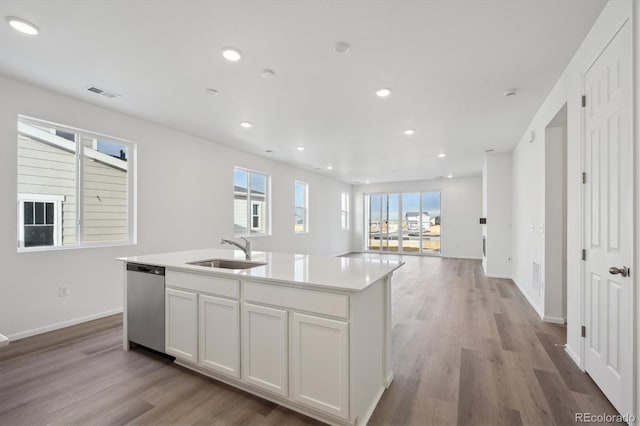 kitchen with dishwasher, white cabinets, a center island with sink, sink, and light hardwood / wood-style flooring