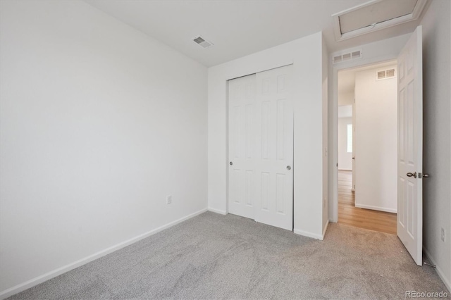 unfurnished bedroom featuring light carpet and a closet