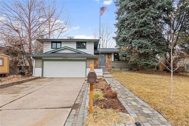 tri-level home featuring brick siding, a front lawn, a chimney, and driveway