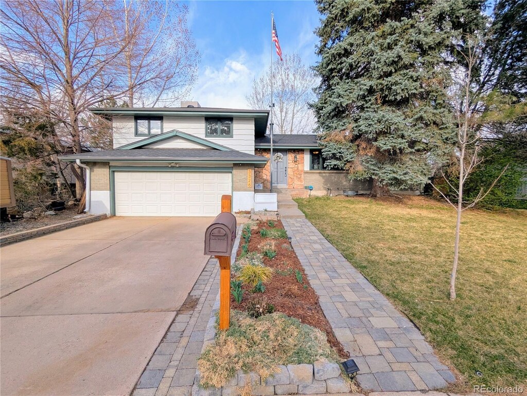 3326 S Geneva St, Denver, CO 80231 - tri-level home with driveway, a garage, and a front lawn
