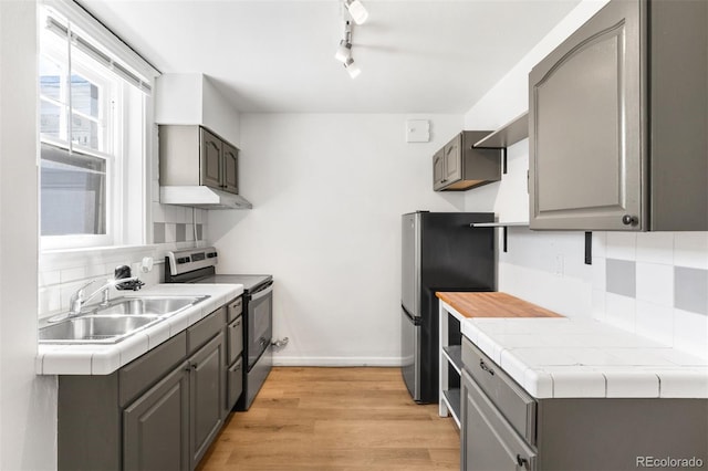 215 E 11th Ave Unit D5, Denver, CO 80203 - kitchen with stainless steel appliances, gray cabinetry, a sink, and tasteful backsplash