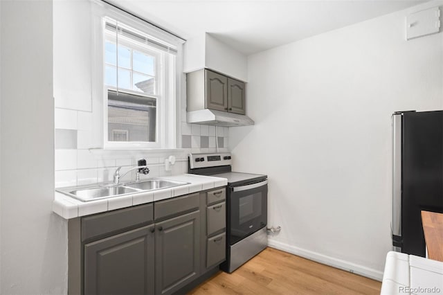 215 E 11th Ave Unit D5, Denver, CO 80203 - kitchen with appliances with stainless steel finishes, gray cabinets, a sink, and under cabinet range hood