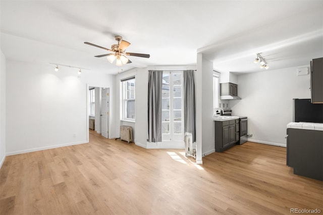 215 E 11th Ave Unit D5, Denver, CO 80203 - unfurnished living room with rail lighting, ceiling fan, light wood-style floors, and radiator heating unit