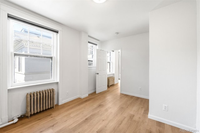 215 E 11th Ave Unit D5, Denver, CO 80203 - spare room with radiator, light wood-style floors, and baseboards