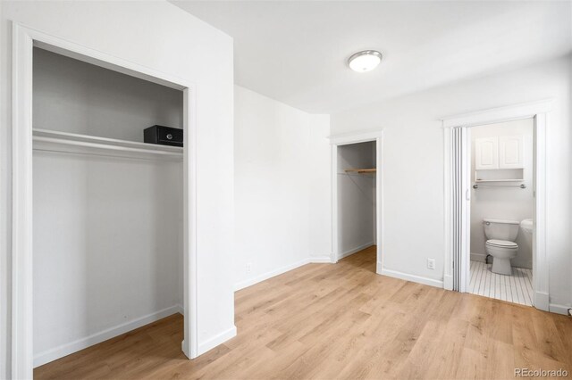 215 E 11th Ave Unit D5, Denver, CO 80203 - unfurnished bedroom featuring wood finished floors, baseboards, and connected bathroom