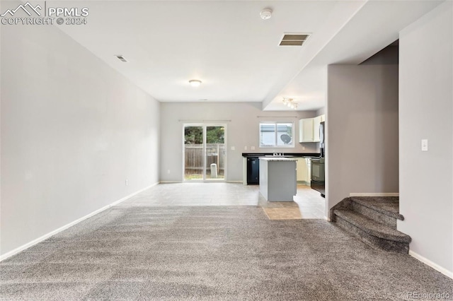 unfurnished living room featuring light carpet