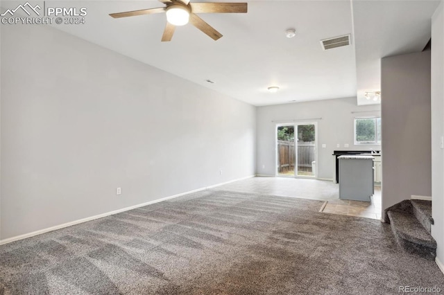 unfurnished living room with ceiling fan and light colored carpet