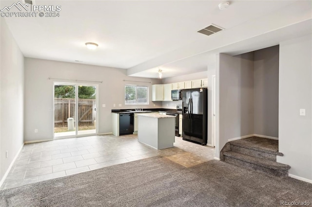 kitchen featuring black appliances, a center island, white cabinetry, and light tile patterned floors