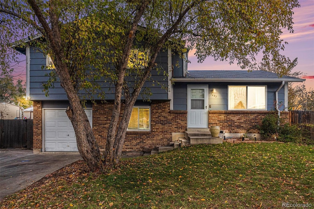 view of front facade featuring a garage and a yard