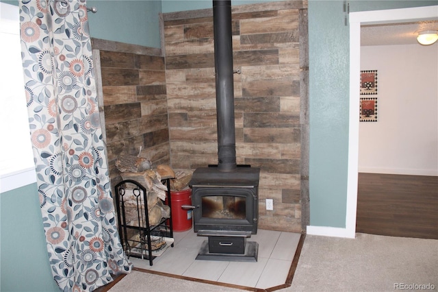 interior details with a wood stove and wood-type flooring