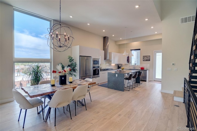 5125 W 29th Ave Unit 1, Denver, CO 80212 - dining area with a high ceiling, light wood finished floors, recessed lighting, a chandelier, and baseboards