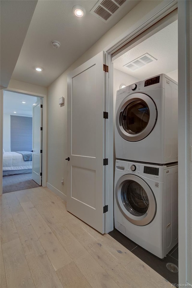 5125 W 29th Ave Unit 1, Denver, CO 80212 - washroom featuring stacked washer / dryer, light wood finished floors, recessed lighting, and baseboards
