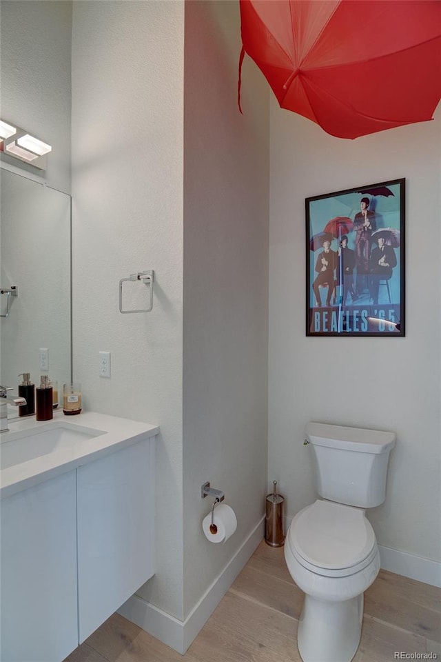 5125 W 29th Ave Unit 1, Denver, CO 80212 - bathroom featuring vanity, toilet, wood finished floors, and baseboards