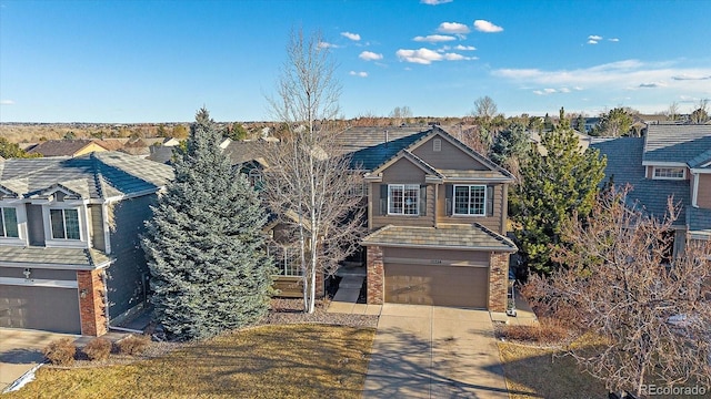 view of front of home with driveway, an attached garage, and brick siding