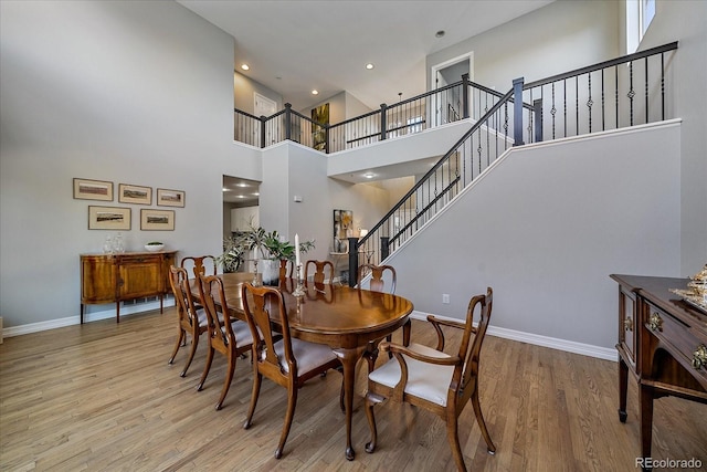 dining space with stairs, baseboards, wood finished floors, and recessed lighting