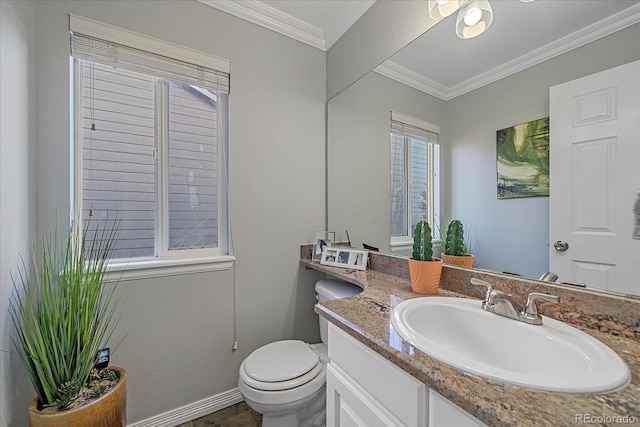 bathroom featuring baseboards, vanity, toilet, and crown molding