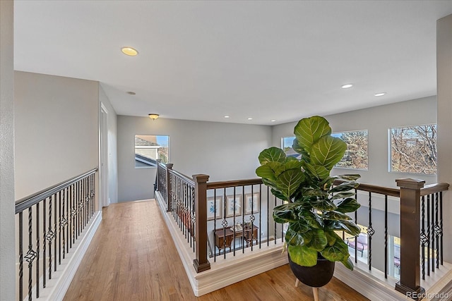 corridor featuring recessed lighting, wood finished floors, and an upstairs landing