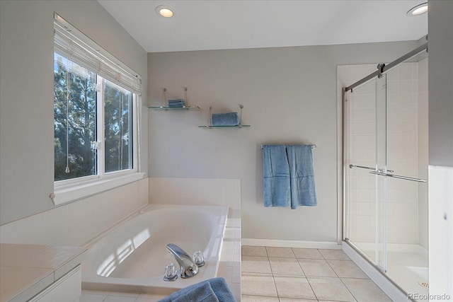 bathroom featuring a stall shower, tile patterned flooring, baseboards, and a garden tub