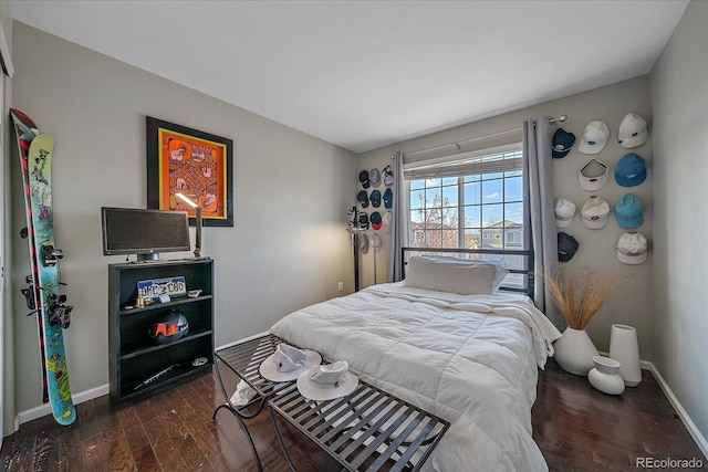 bedroom with dark wood finished floors and baseboards