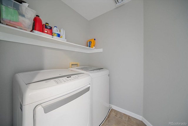 clothes washing area featuring baseboards, laundry area, washing machine and dryer, and tile patterned floors