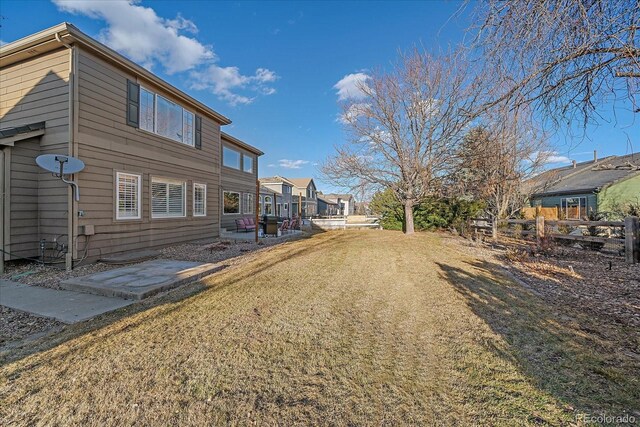 rear view of property with a lawn and fence