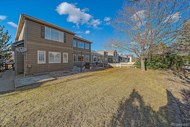 rear view of property featuring a lawn and a patio area