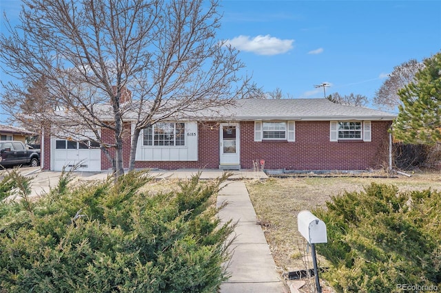 single story home featuring brick siding, a shingled roof, an attached garage, board and batten siding, and driveway