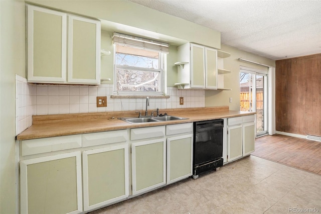 kitchen featuring open shelves, tasteful backsplash, a sink, a textured ceiling, and dishwasher