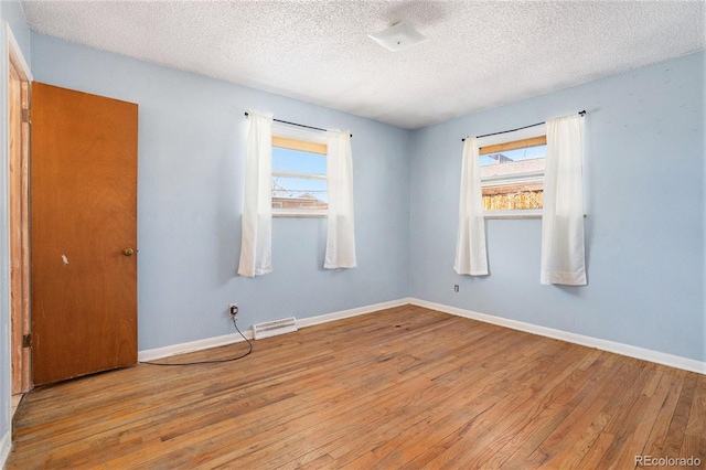 unfurnished room featuring visible vents, a healthy amount of sunlight, light wood-style flooring, and baseboards