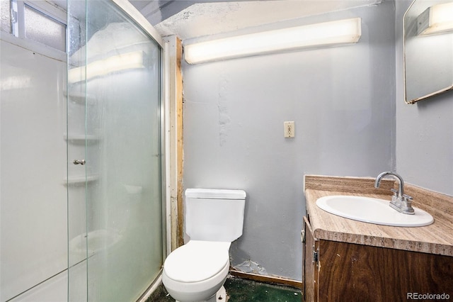 full bath with toilet, a stall shower, baseboards, and vanity