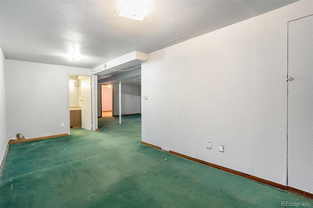 unfurnished room featuring carpet floors, baseboards, and a textured ceiling