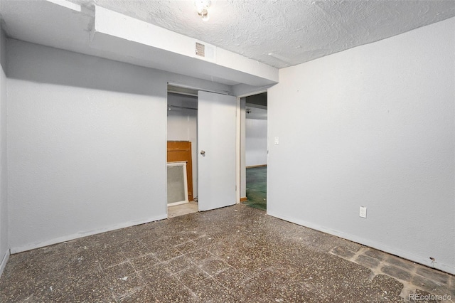 empty room featuring visible vents, a textured ceiling, and tile patterned floors