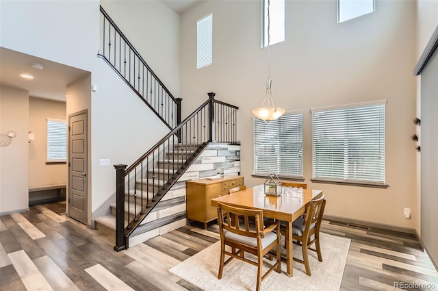 6883 E 132nd Pl, Thornton, CO 80602 - dining space with a high ceiling, wood finished floors, stairs, and healthy amount of natural light