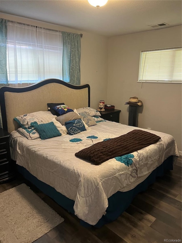 bedroom with visible vents and wood finished floors