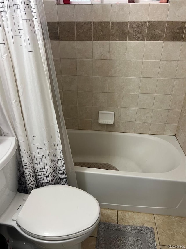 bathroom featuring toilet, tile patterned flooring, and shower / bath combo with shower curtain