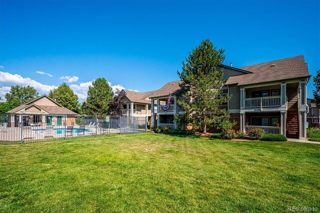 view of yard with a balcony, a patio, and a fenced in pool