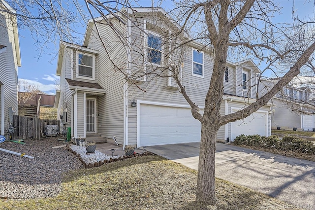 view of front of house with an attached garage, driveway, and fence