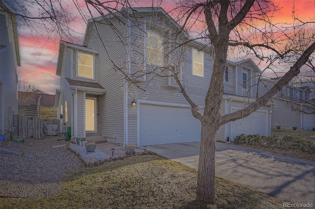 traditional-style house with concrete driveway, an attached garage, and fence