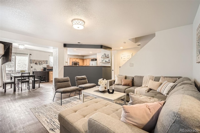 living room with light wood-style flooring and a textured ceiling