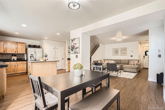 dining room with dark wood-type flooring, recessed lighting, a textured ceiling, and baseboards