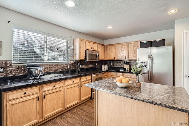 kitchen with appliances with stainless steel finishes, dark wood-style flooring, backsplash, and a textured ceiling