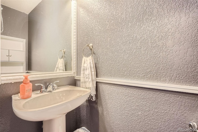 bathroom with a textured wall and a sink