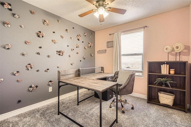 carpeted office space with ceiling fan, baseboards, and a textured ceiling