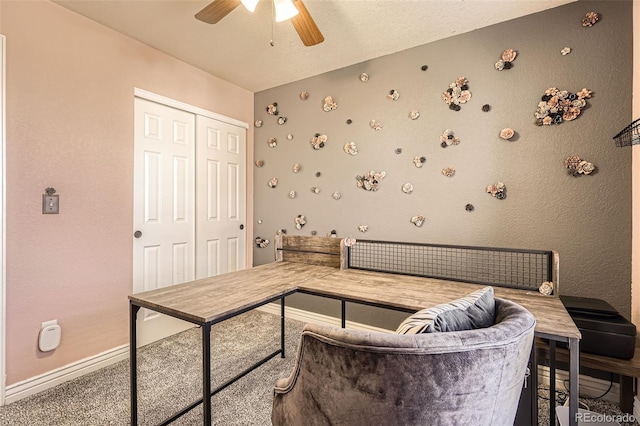 living room featuring carpet floors, a textured ceiling, baseboards, and a ceiling fan